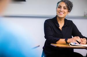 An adult student in a class smiling.