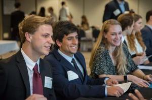 学生 wearing business attire sit in a conference.